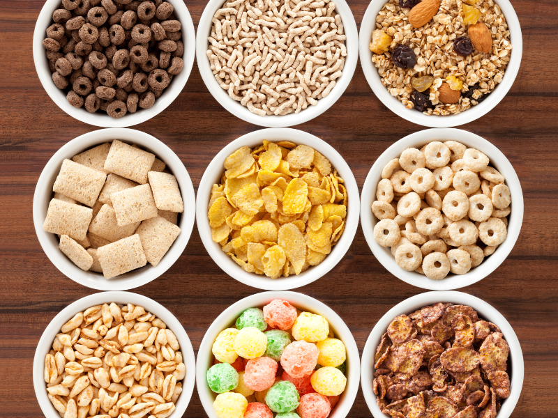 9 bowls of ultra-processed food breakfast cereals on a wooden table