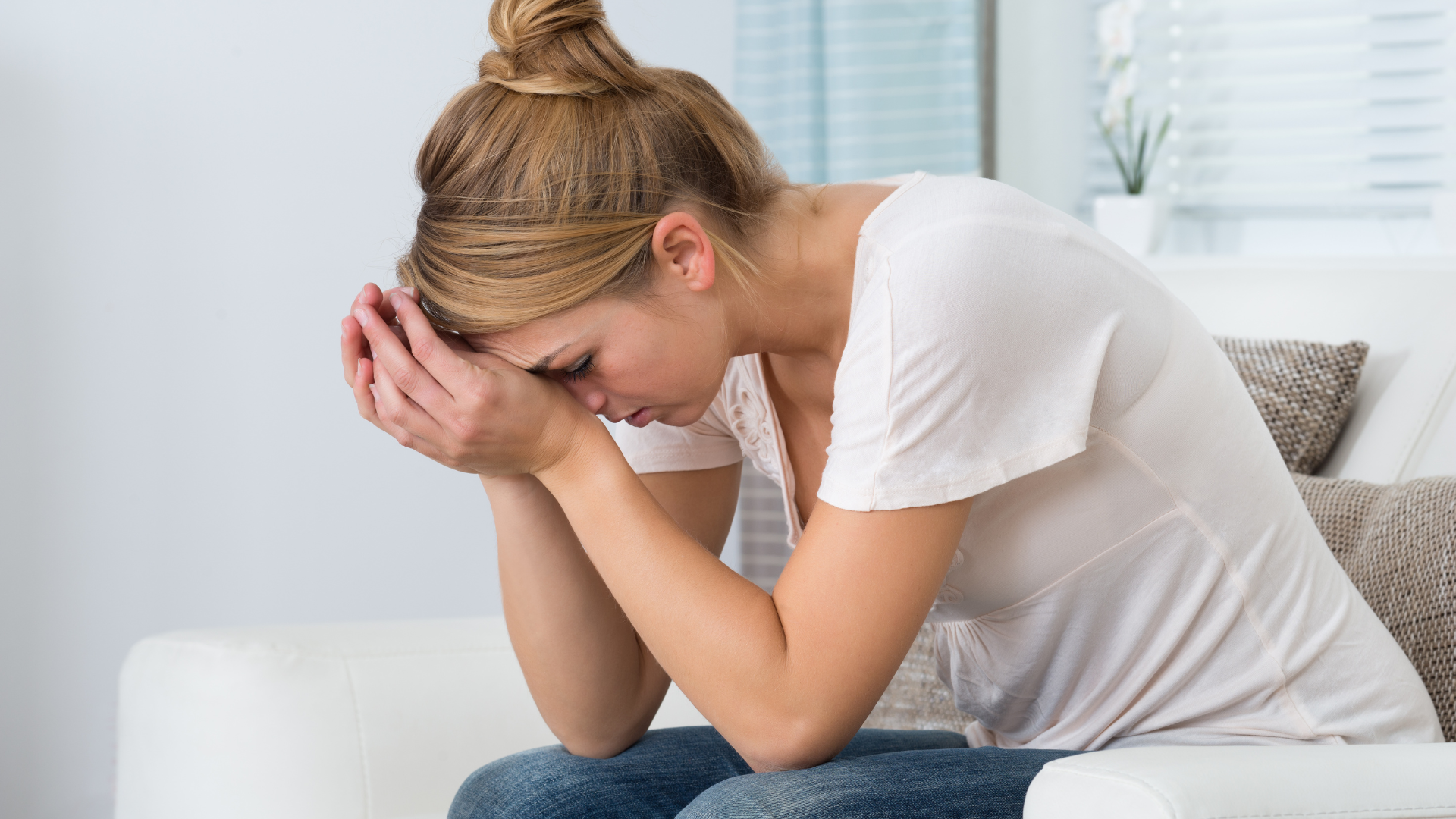 Exhausted woman running on empty and sitting with her head in her hands.